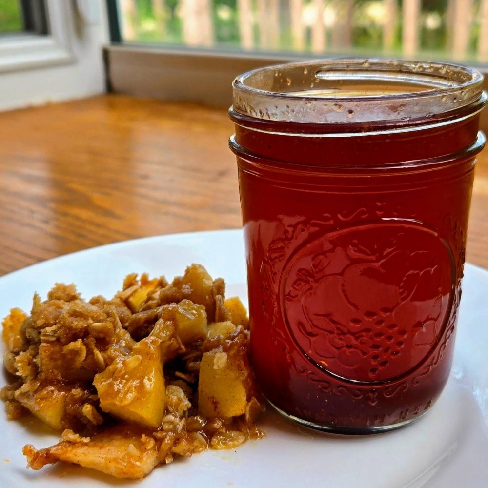 apple crisp syrup on plate next to apple crisp